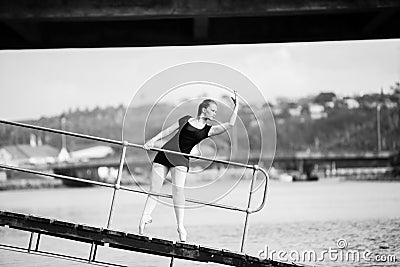 Ballerina leaning through a bridge railing