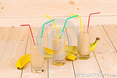 Banana smoothie and fruits on wood.