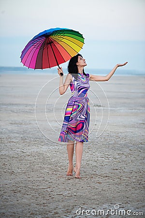 Barefooted woman with colorful umbrella