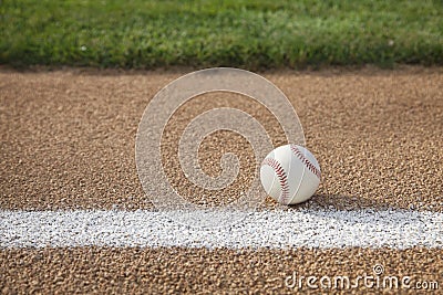 Baseball on base path with grass infield