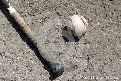 Baseball bat and ball in dirt