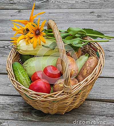 Basket with vegetables and a bouquet of yellow rudbeckia