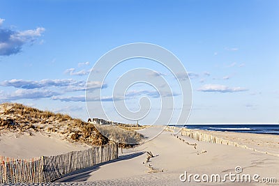 Beach Fence, Sand, Houses and the Ocean.