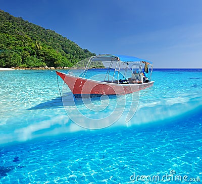 Beach and motor boat with white sand bottom