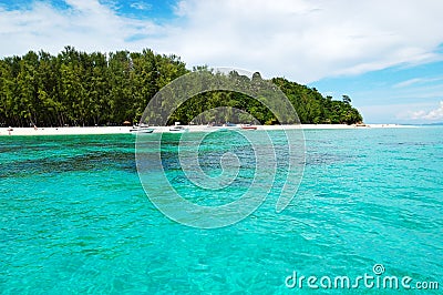Beach with motor boats on turquoise water