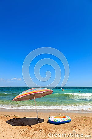 Beach umbrella and toy boat at sea