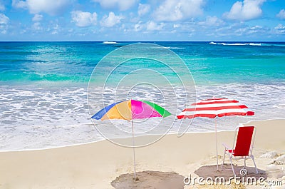 Beach umbrellas and chair by the ocean