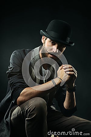 The bearded man in a bowler hat clenched his hands into the lock