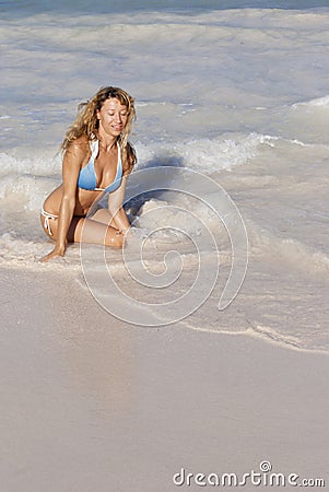 Beatiful woman in bikini sitting on the beach