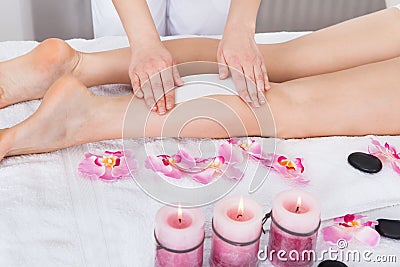 Beautician waxing woman s leg