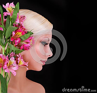 Beautiful blonde young woman with pink irises flowers over black, fashion model