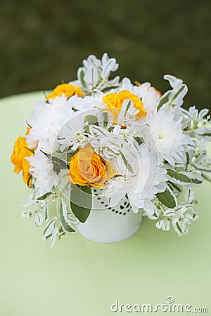 Beautiful bouquet of bright flowers in white vase, on bright background