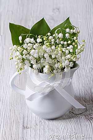 Beautiful bouquet of lilies of the valley in a white jug