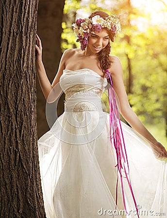 Beautiful bride with flower tiara at the tree