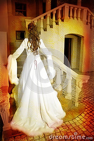 Beautiful bride in long silk coat on staircase