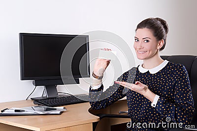 Beautiful business woman showing visiting card in office and pc