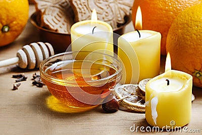Beautiful candles, bowl of honey and fresh orange