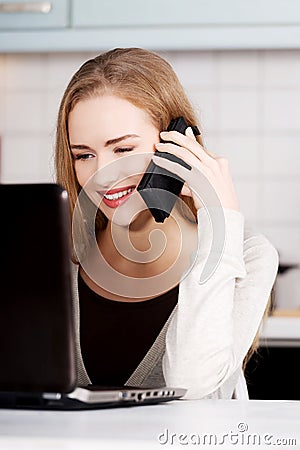Beautiful caucasian woman talking through phone and working with