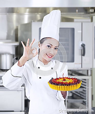 Chef holding delicious cake at work