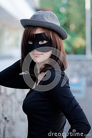 Beautiful elegant woman in a hat and carnival mask