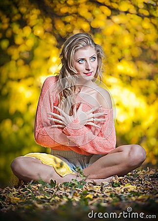 Beautiful elegant woman with long legs in autumn park