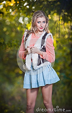 Beautiful elegant woman with long legs in autumn park .