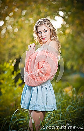 Beautiful elegant woman with long legs in autumn park .