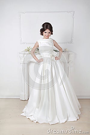 Beautiful fashion bride in wedding luxurious dress posing agains