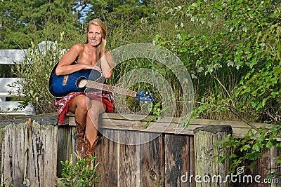 Beautiful female guitar player outdoors