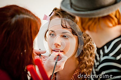 Beautiful female having her make up done by a make up artist tea