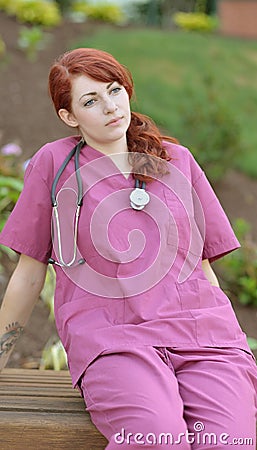 Beautiful female medical professional in scrubs outside