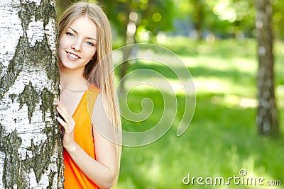 Beautiful female peeping from behind tree