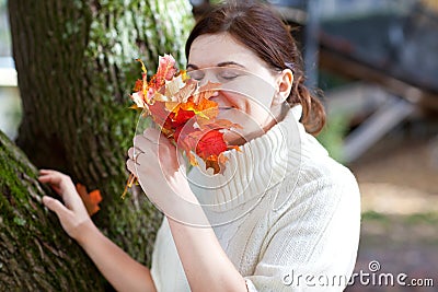 Beautiful girl in the autumn park collects leaves