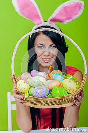 Beautiful girl with a basket of Easter eggs i