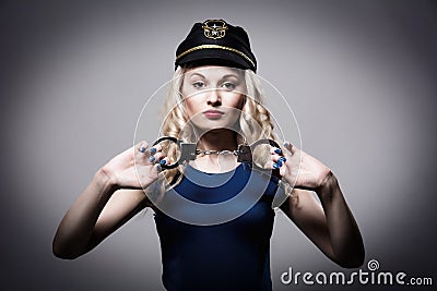 Beautiful girl with handcuffs and a police cap