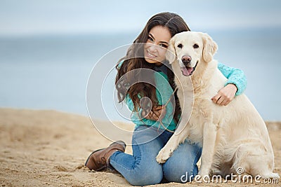Beautiful girl with her dog near sea