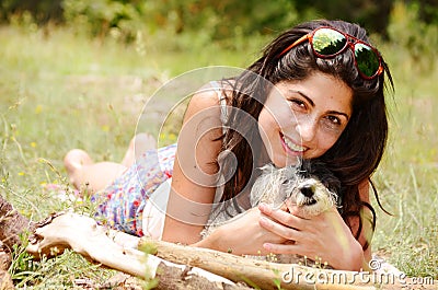 Beautiful girl hugging her dog in the mountain