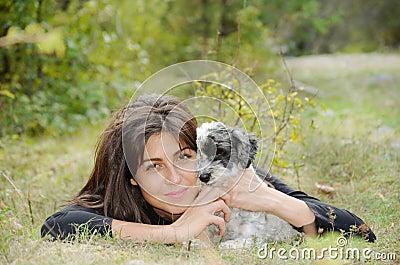 Beautiful girl hugging her dog in the mountain