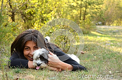 Beautiful girl hugging her dog in the mountain