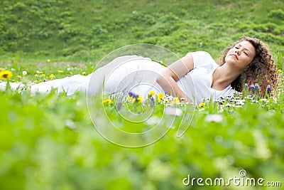 Beautiful girl laying on flowers field,outdoor summer