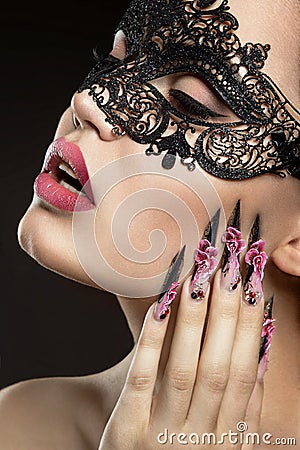 Beautiful girl in a mask with long fingernails.