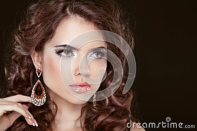 Beautiful girl model with curly long hair and fashion earrings i