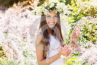 Beautiful girl on the nature in wreath of flowers