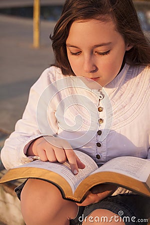 Beautiful girl reading holy bible
