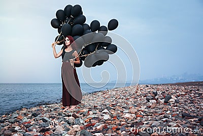 Beautiful girl walking with black balloons