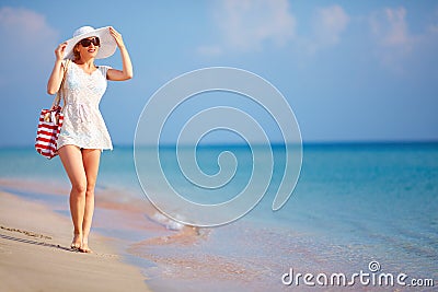 Beautiful girl walking the summer beach