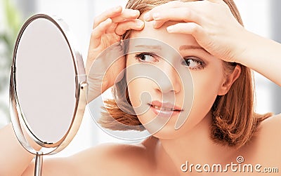 Beautiful healthy woman frightened saw in mirror acne and w