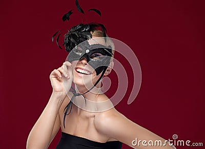 Beautiful lady with black masquerade mask with feathers