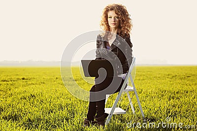 Beautiful lady with her laptop on grass