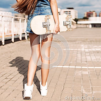 Beautiful lady with long silky hair in denim short overalls